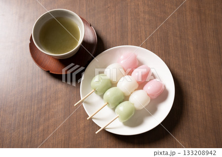 白い皿にのった三色団子とお茶 133208942