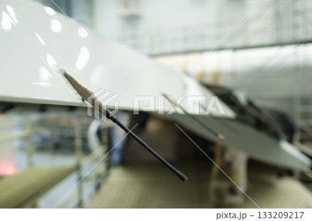 Precision instruments attached to a sleek aircraft wing inside a modern aerospace facility during a detailed engineering examination Precision instruments attached to a sleek aircraft wing inside a modern aerospace facility during a detailed engineering examination 133209217