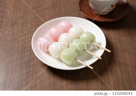 白い皿にのった3本の三色団子とお茶 133209243