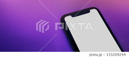 Close up of smartphone with white screen on pink purple neon surface Close up of smartphone with white screen on pink purple neon surface 133209244