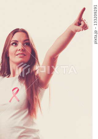 Woman pink cancer ribbon on chest pointing Woman pink cancer ribbon on chest pointing 133209291