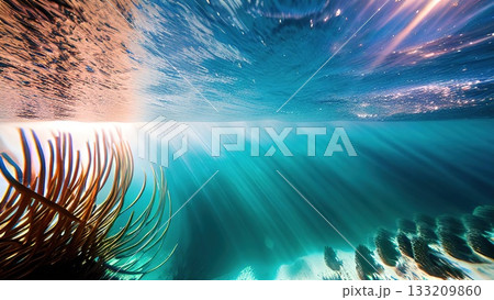 A peaceful underwater view showcasing the delicate ripples on a sandy seafloor, bathed in the soft glow of sunlight through clear blue ocean water. 133209860