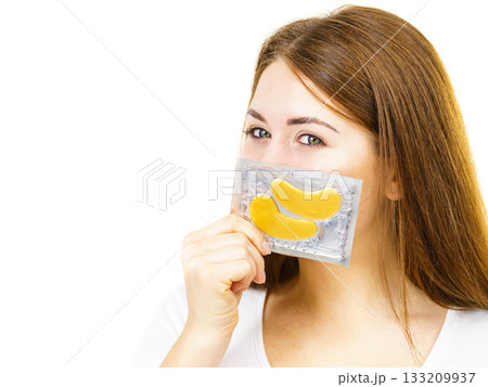 Woman ready to apply gold eye patches Woman ready to apply gold eye patches 133209937