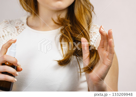 Woman applying hair cosmetic 133209948