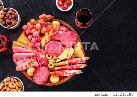 Italian Antipasti. Charcuterie platter with cheese and other snacks, with wine Italian Antipasti. Charcuterie platter with cheese and other snacks, with wine 133210190