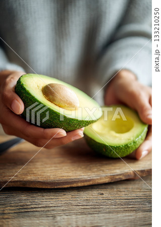 A close-up of a person's hands slicing a ripe avocado, revealing its creamy green interior, perfect for healthy fats. A close-up of a person's hands slicing a ripe avocado, revealing its creamy green interior, perfect for healthy fats. 133210250