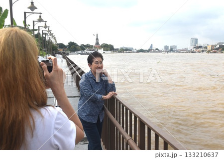 daughter used camera photo mother at landscape of Cho phraya river in Thailand on rainy day 133210637