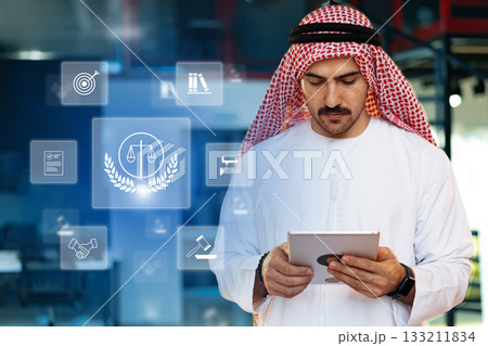 Professional man in traditional dress using tablet for legal research in modern office 133211834