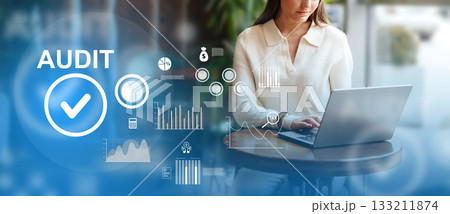 Professional audit work at a laptop in a modern office setting during the day 133211874