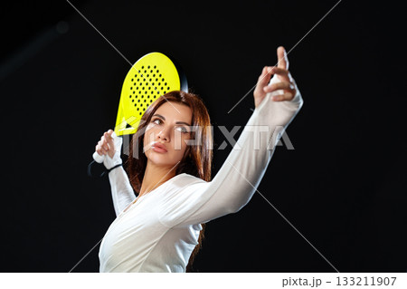 Woman preparing to serve in a tennis match on a dark background Woman preparing to serve in a tennis match on a dark background 133211907
