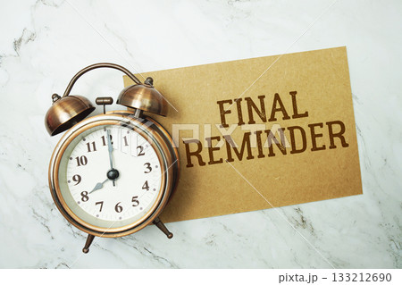 Final Reminder text written on paper card with alarm clock on marble background Final Reminder text written on paper card with alarm clock on marble background 133212690