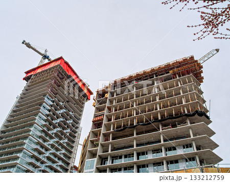 High rise monolith concrete buildings with the cranes above 133212759