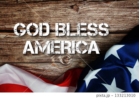 God Bless America text message with USA flag on wooden background God Bless America text message with USA flag on wooden background 133213010