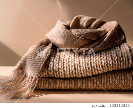 柔らかな中間色背景に置かれた冬のマフラー 133213830