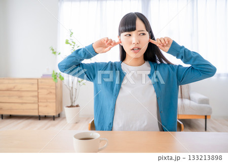 耳を塞ぐ若い女性 133213898