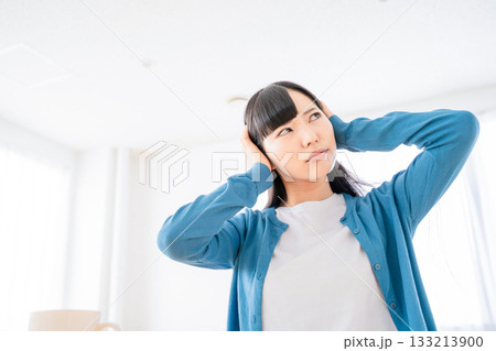 耳を塞ぐ若い女性 133213900