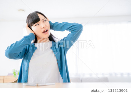 耳を塞ぐ若い女性 133213901