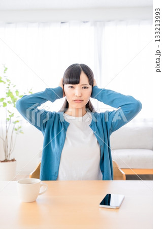 耳を塞ぐ若い女性 133213993
