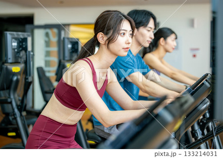 スポーツジムでアップライトバイクを使う男女 133214031