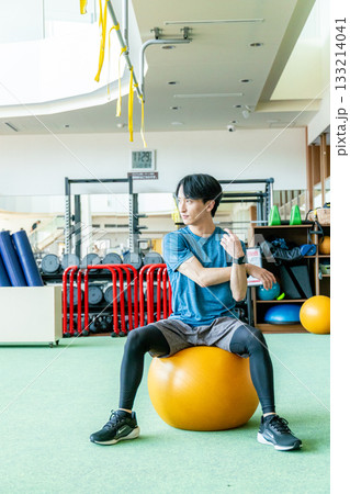 バランスボールに乗る男性 133214041