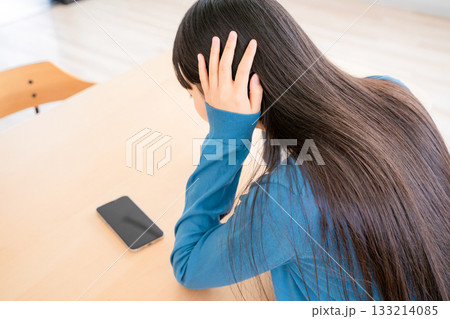 耳を塞ぐ若い女性 133214085