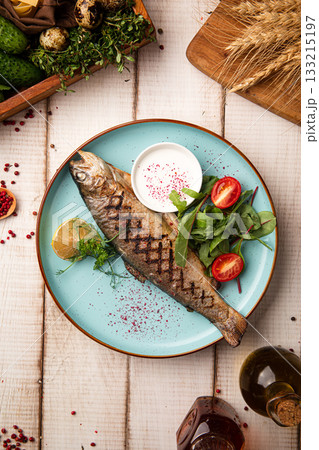 Grilled whole fish with greens and sauce Grilled whole fish with greens and sauce 133215197