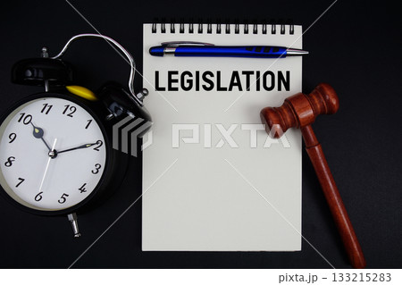 Legislation text written on notepad with gavel and alarm clock on black background Legislation text written on notepad with gavel and alarm clock on black background 133215283