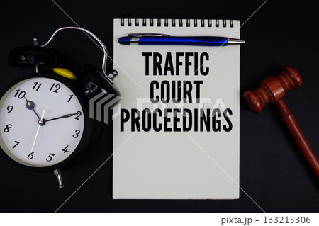 Traffic Court Proceedings text written on notepad with gavel and alarm clock on black background 133215306