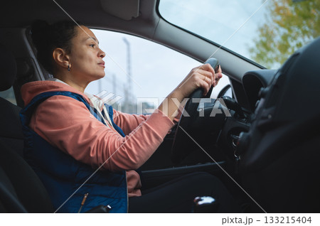 Focused Driver In A Cozy Car Cabin, Woman Steering With Calm Confidence On A Day Drive 133215404