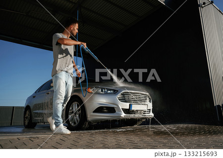 Walking around and washing the automobile. Man is with his car outdoors Walking around and washing the automobile. Man is with his car outdoors 133215693