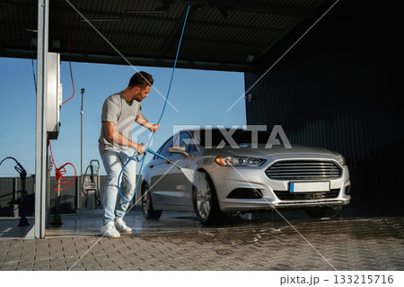Service of car wash. Man is with his automobile outdoors 133215716