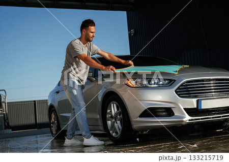 Cloth, cleaning the automobile. Man is with his car outdoors 133215719