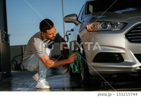 Business of car washing, polishing. Man is with automobile outdoors Business of car washing, polishing. Man is with automobile outdoors 133215744
