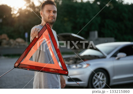 Broken car, red sign. Man is with his automobile outdoors Broken car, red sign. Man is with his automobile outdoors 133215860