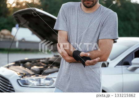 Pain is in the hand, accident, broken automobile. Man is with his car outdoors 133215862