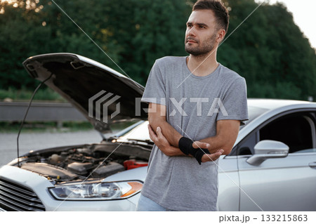 Pain is in the hand, accident, broken automobile. Man is with his car outdoors Pain is in the hand, accident, broken automobile. Man is with his car outdoors 133215863