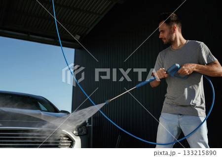 Taking care of washing. Man is with his car outdoors 133215890