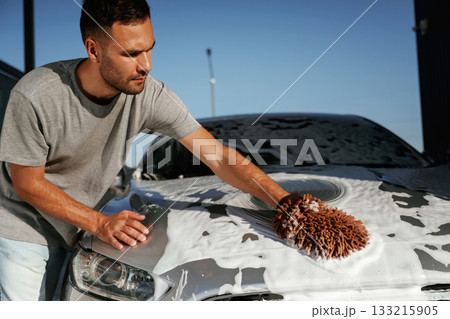 White cleaning chemical, washing the automobile. Man is with his car outdoors White cleaning chemical, washing the automobile. Man is with his car outdoors 133215905
