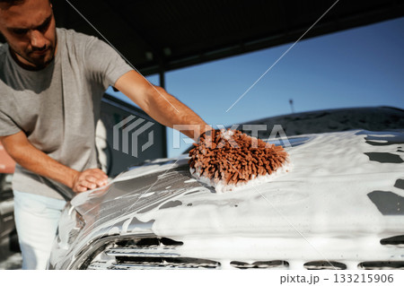 White cleaning chemical, washing the automobile. Man is with his car outdoors White cleaning chemical, washing the automobile. Man is with his car outdoors 133215906
