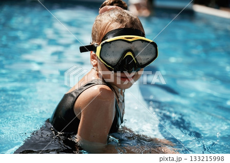 In swimming mask. Happy little girl is having fun in the pool 133215998