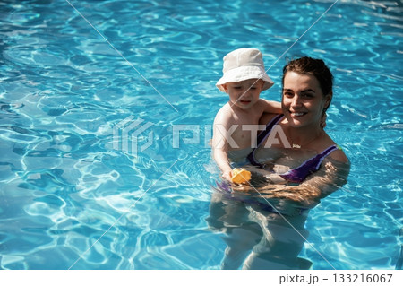 Happy mother with her little son are in the pool Happy mother with her little son are in the pool 133216067