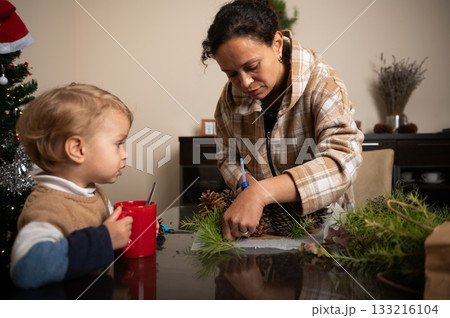Holiday Craft Time: Mom And Child Decorate Pinecones And Greens For Christmas At Home 133216104