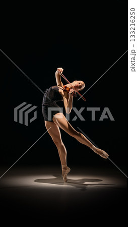 Ballerina in dramatic leaning pose playing violin with extended leg Ballerina in dramatic leaning pose playing violin with extended leg 133216250