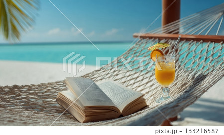Open book and a refreshing tropical drink on a hammock Open book and a refreshing tropical drink on a hammock 133216587