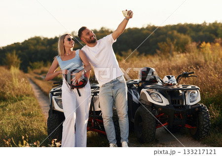 Making a selfie. Man and woman are on ATV outdoors 133217121