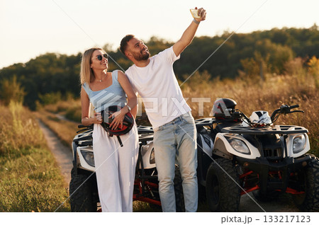 Doing the selfie. Man and woman are on ATV outdoors 133217123