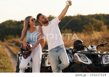 Doing the selfie. Man and woman are on ATV outdoors Doing the selfie. Man and woman are on ATV outdoors 133217124