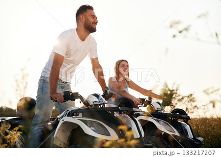 Under sunlight. Man and woman are on ATV outdoors 133217207