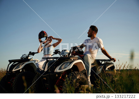 Rest time, sitting and taking a break. Man and woman are on ATV outdoors Rest time, sitting and taking a break. Man and woman are on ATV outdoors 133217222