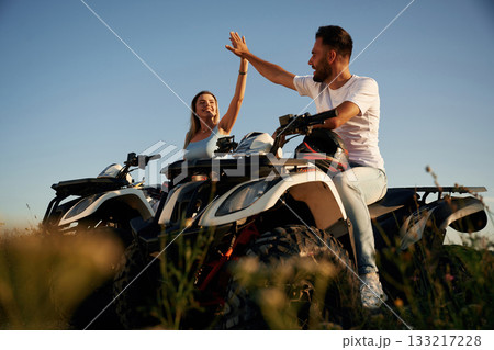 Rest time, sitting and taking a break. Man and woman are on ATV outdoors Rest time, sitting and taking a break. Man and woman are on ATV outdoors 133217228